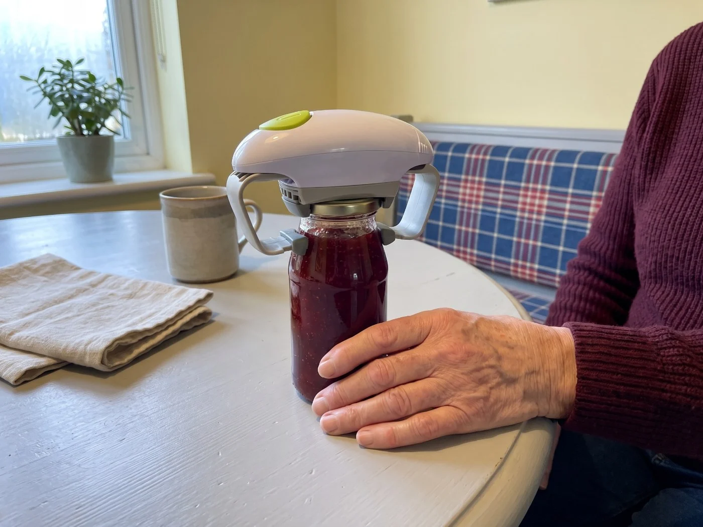 Twist Buddy Pro opening a jam jar while older hands rest nearby