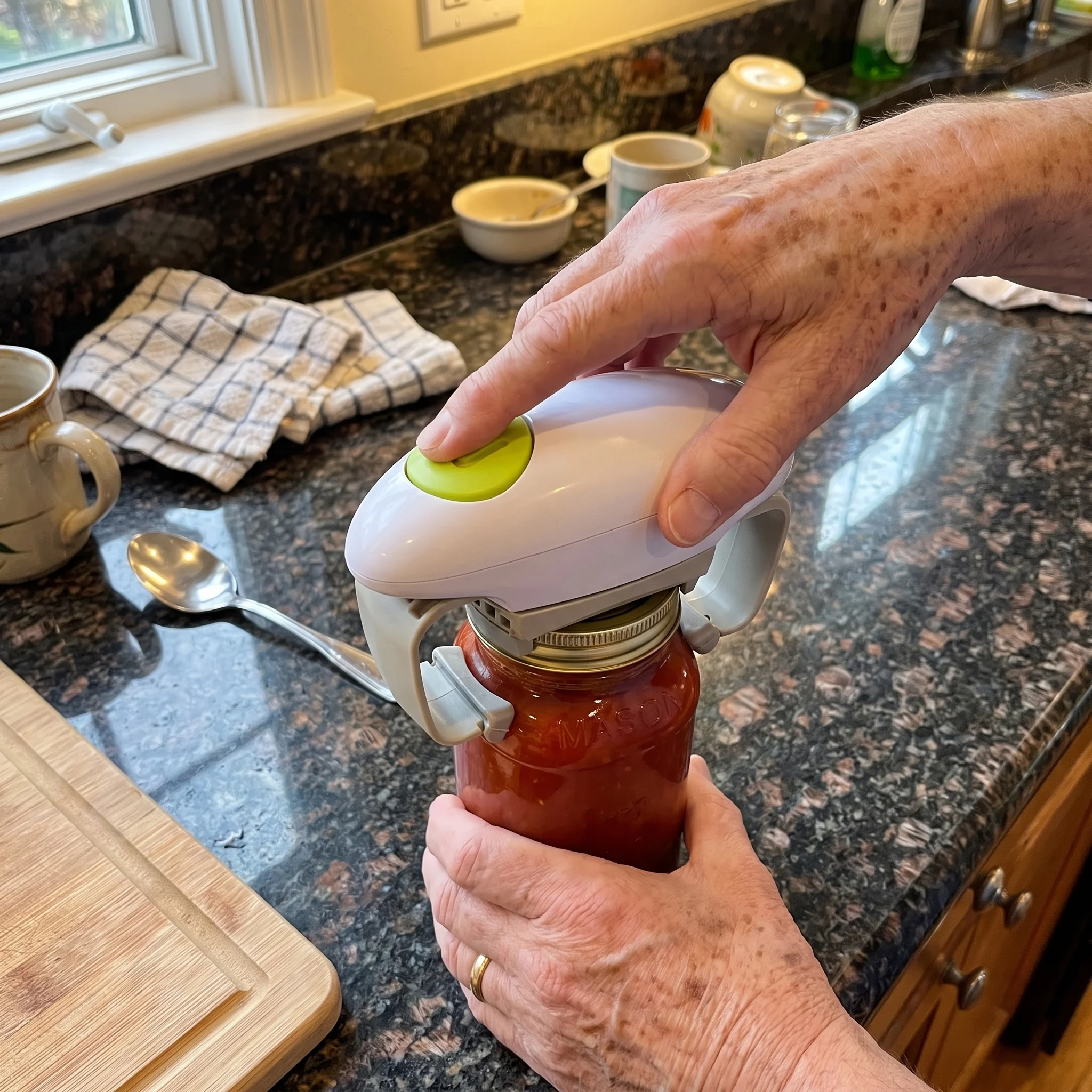 Twist Buddy Pro opening a jar of sauce on a granite counter