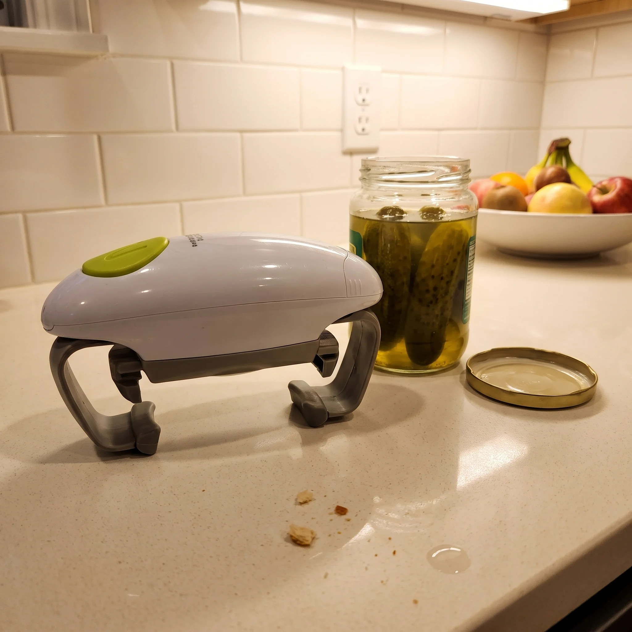 Twist Buddy Pro on a counter beside an opened pickle jar